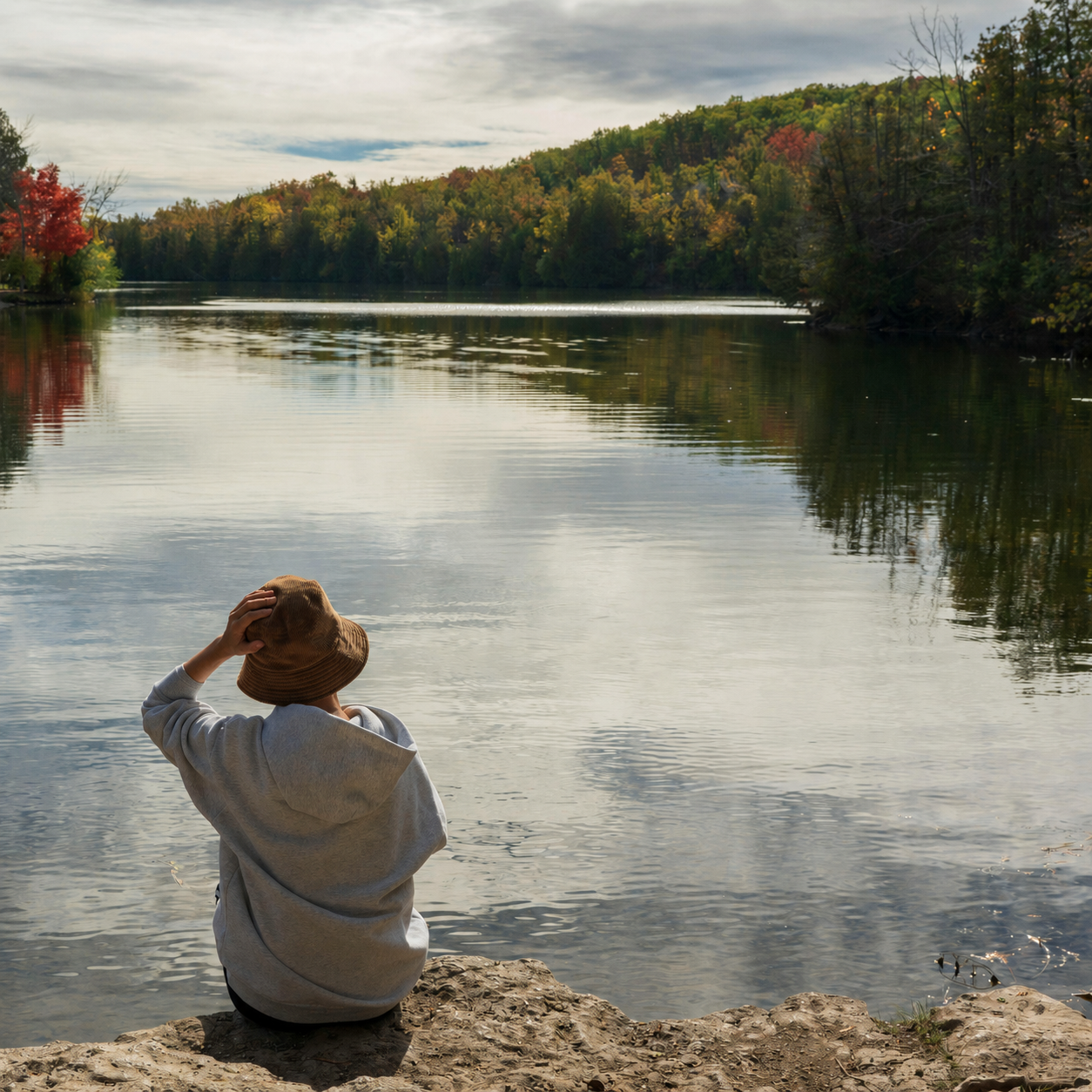 Woman sitting quietly beside a lake on Manitoulin Island